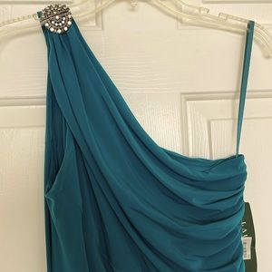 Teal one-shoulder gown with rhinestone embellishment.